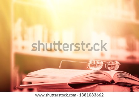 Stack of books in the library and blur bookshelf background