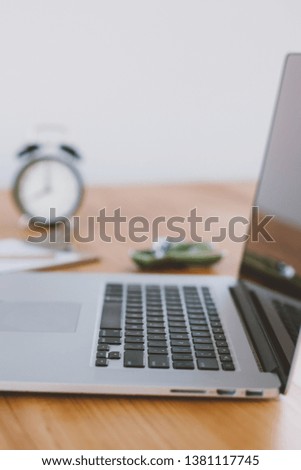 Comfortable working place in home office with wooden table and modern laptop laying on it. Freelance work concept