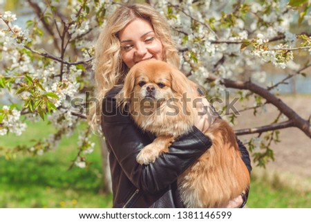 Portrait of nice woman and her dog in garden, pets concept
