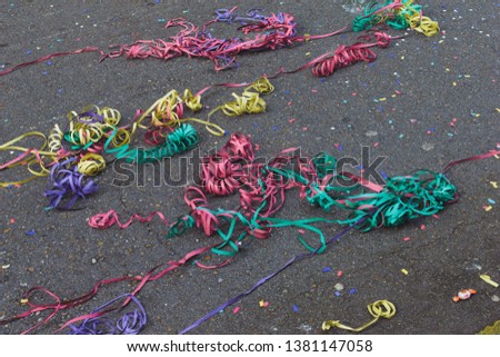 carnival serpentines on the road after celebration. Garbage after festival