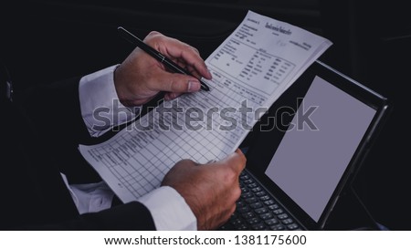 Closeup hand of Businessman wearing suits holding Documents and Check the business authorization documents. business concept.