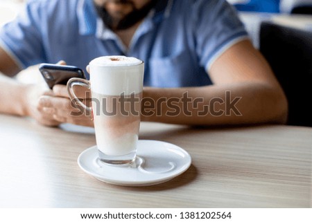 cropped photo of  man with cup of coffee looking at mobile phone outdoors - Image      