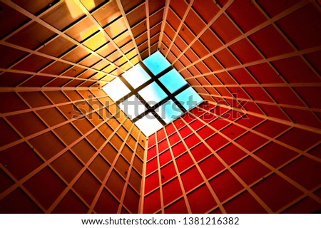 Abstract perspective photograph of vertical lobby ceiling with skylight and strong geometry and symmetry and dramatic colors as background 