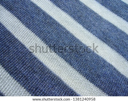 Summer knitted fabric in blue and white stripes. The texture of the fabric. Striped fabric.