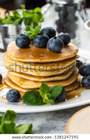 Homemade pancakes with fresh blueberries, maple syrup and mint stacked on plate– stock image