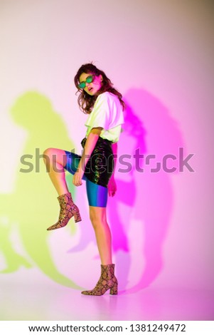 young woman in sunglasses posing on purple with gradient    