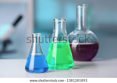 Laboratory glassware with samples on table indoors. Solution chemistry