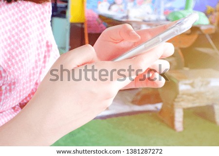 Female hands holding smartphone to take photo and surfing internet in cafe. And Female arm wearing a wristwatch for seeing time.Close up.