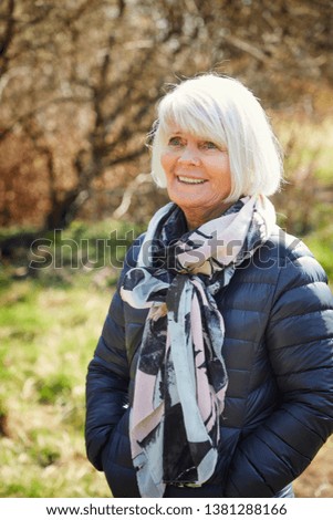 Beautiful senior lady in scarf and jacket, smiling