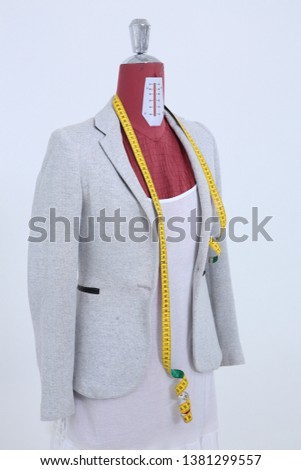 Red mannequin with clothing on white background, measurement.