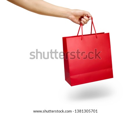 Hand holding a red color shopping bag isolated on white Royalty-Free Stock Photo #1381305701