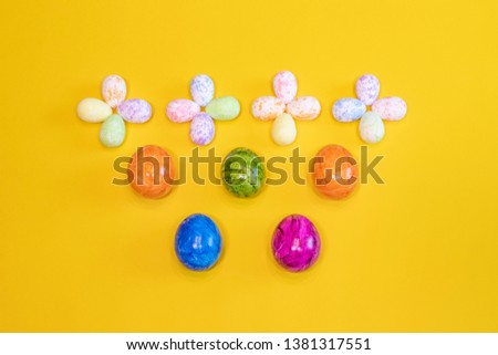 A lot of colorful Easter eggs on a yellow background. Top view, minimal Easter concept. Happy Easter card with free, empty space.