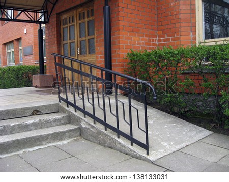 Building entrance with ramp for disabled person wheelchair