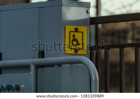 The yellow sign on the lift for wheelchair users