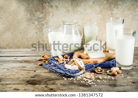 plant based vegan food and drink, Non-dairy milk and cheese tofu - from almond, nuts, soy beans, oats and coconut, wooden background copy space