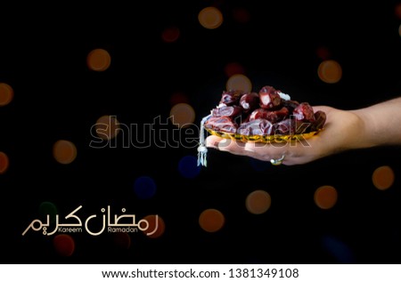 Ramadan Kareem holding dates ramazan Mubarak  cover hand holding dates with golden plate & tashbi bokeh background blur calligraphy Young men holding a bowl of dates with tasbeeh
