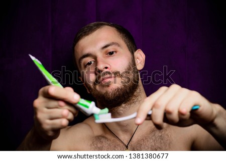 Guy with toothpaste and brush on a dark background