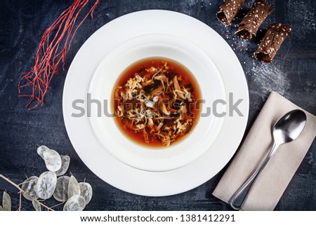 Top view on crab soup served in white plate on dark background. Flat lay food for lunch. Seafood. Reaydy for eat. Picture for recipe. Copy space for design. View from above
