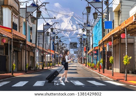 Woman walking on the road in Fujiyoshida with background of Fuji mountain, Japan.