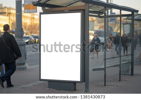 Vertical billboard lightbox in the city advertising in the bus shelter. for placing the MOCKUP advertisement with people in the background