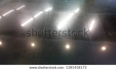 Light reflections on the black tile floor.