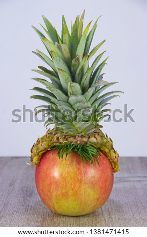 Pineapple hat on apple. It's the basis for drawing a funny human face.