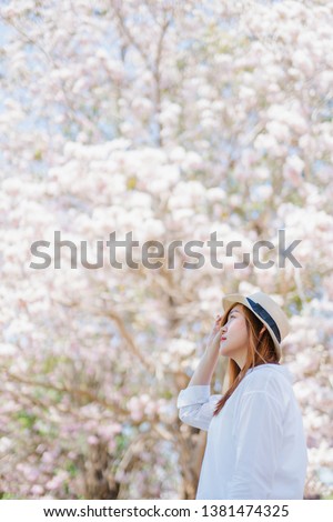 spring season with full bloom pink flower travel concept from beauty asian woman enjoy with sight seeing sakura or cherry blossom with soft focus flower background