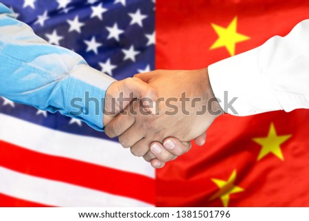 Business handshake on the background of two flags. Men handshake on the background of the American and Chinese flag. Support concept