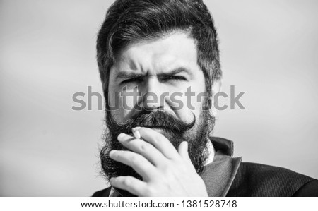 Cigarettes help us with everything from boredom to anger management. Man with beard mustache hold cigarette. Bearded hipster smoking cigarette sky background. Guy cigarette enjoy nicotine influence.