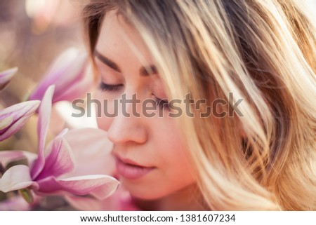 Portrait of a beautiful young woman near a magnolia.