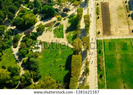 top View of Paris from Eiffel Tower on a sunny day with green trees and people in the park