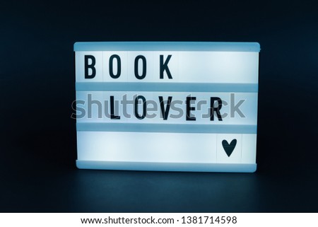Photo of a light box with text, BOOK LOVER, over dark isolated 