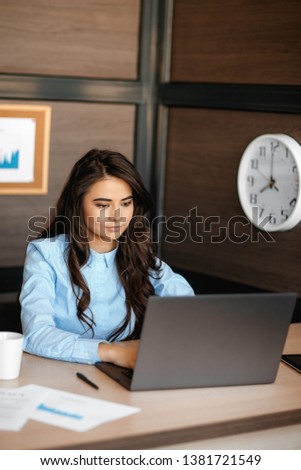 Photo of pretty young manager woman working with laptop in modern office.