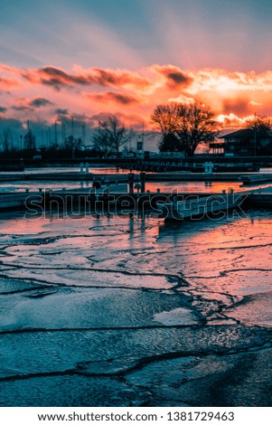 Bursting Orange Sunset Over Frozen Marina