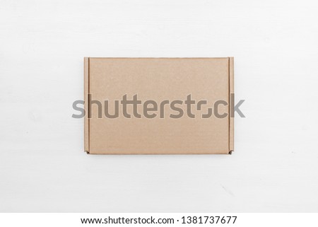 Blank cardboard parcel box on a white table background. Royalty-Free Stock Photo #1381737677