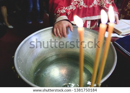 Christening ceremony preparation. A boiler of water with canddles in the foreground.