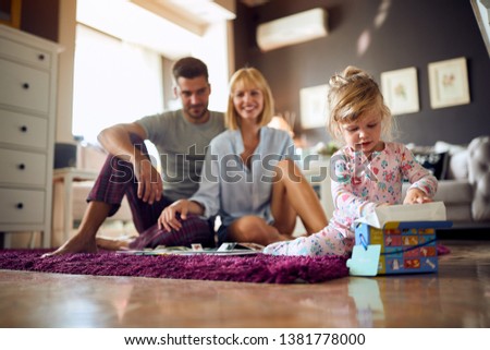 Female child and parents playing in the morning in room
