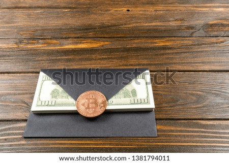 Prop Money Dollars in black envelope.Bitcoin as a seal.Brown wooden background