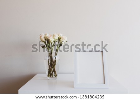 Closeup of blank rectangular picture frame with cream roses on table - matte filter effect