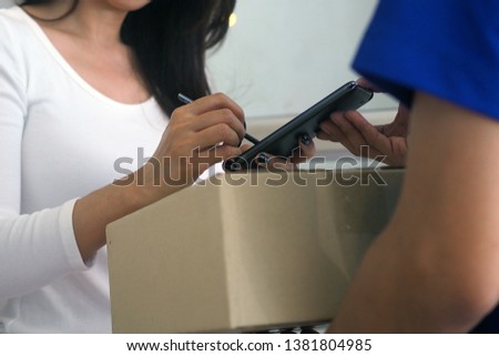 Women's hands signed to receive packets from online purchases The young man sent the smartphone and box