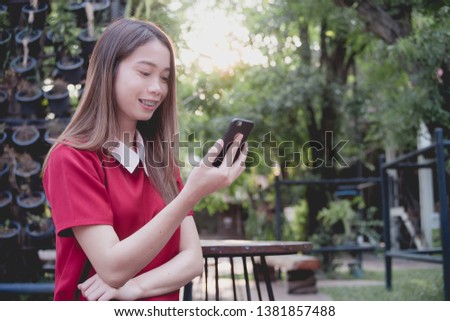 Woman using mobile phone while stand in the park
