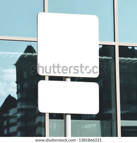 White mock up copy space template for a poster, advertising, road sign on the background of the glass facade of the building