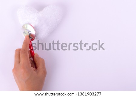 World Red Cross Day Concept. Woman hands holding stethoscope with white heart on white paper background.