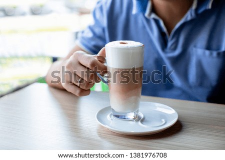 man with cup of coffee latte sitting on a summer terrace in a cafe outdoors - Image   
