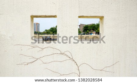A picture of a river over a wall. Two windows are highly utilized.