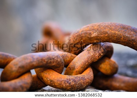 rusty big chain lying on a stone
