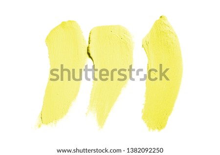 Smear and texture of lipstick or acrylic paint isolated on white background. Stroke of lipgloss or liquid nail polish swatch smudge sample. Element for beauty cosmetic design. Yellow color