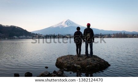 A couple enjoying Sunrise view of Mt Fuji on the northern shore of Lake Kawaguchiko in Japan Royalty-Free Stock Photo #1382124470
