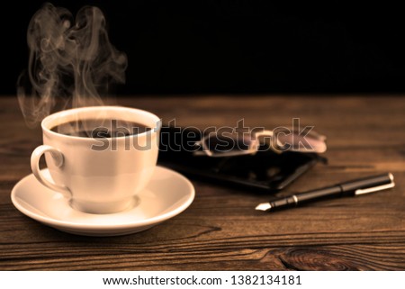 Cup of coffee, smartphone, glasses, fountain pen on wooden table background. 