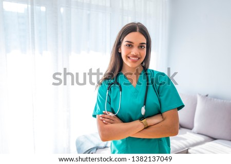 Portrait of young attractive smiling nurse. Hoome nurse. Caucasian woman working in nursing home. Beautiful young nurse woman wearing uniform and stethoscope